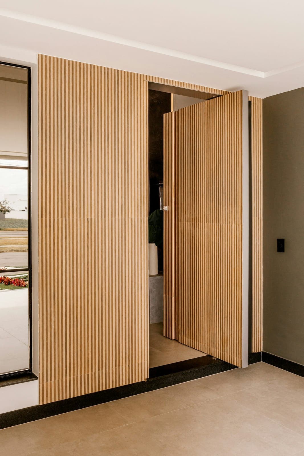 Fluted wood pivot doors in a modern interior